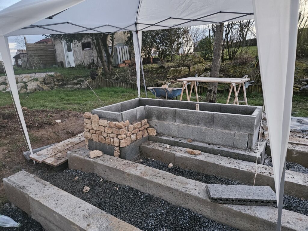 Parement en pierre sèche monté à la main sur la jardinière, un moellon après l'autre.