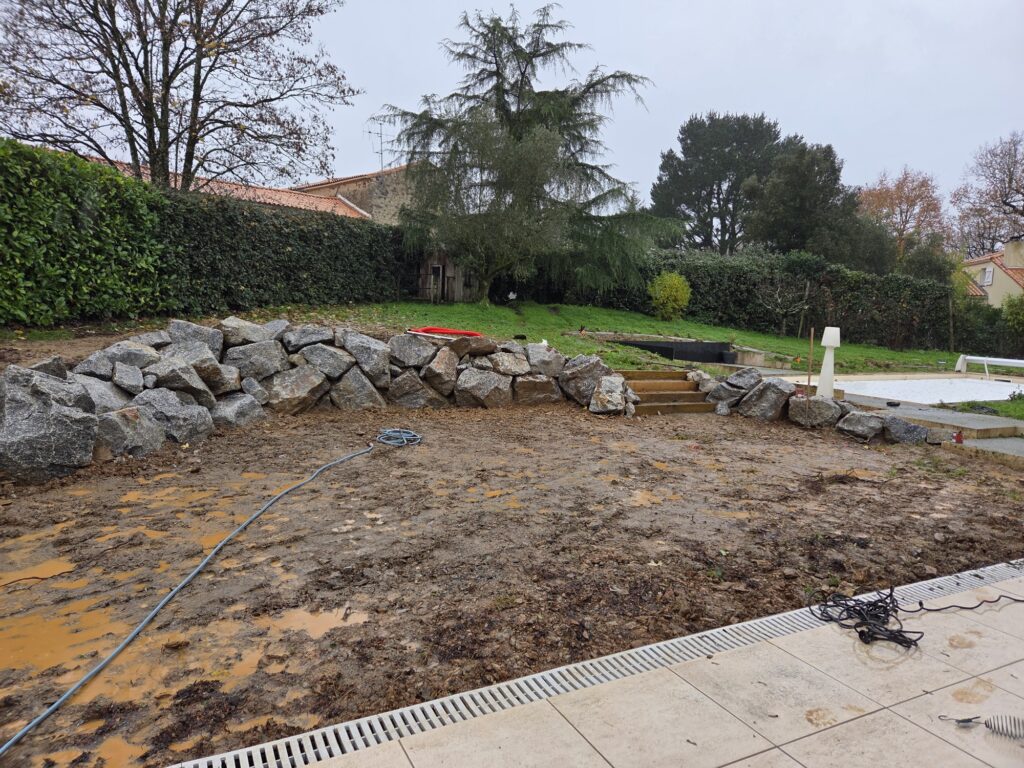 Décembre, boue jusqu'aux chevilles : l'enrochement prend sa place au-dessus du bassin.